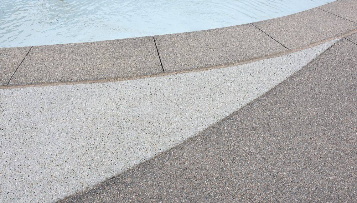 Up close perspective of Sandscape Refined coping and pool deck at apartment complex.