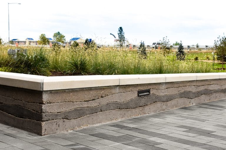 Sedimentary planter walls create a unique layered look around these planter beds.