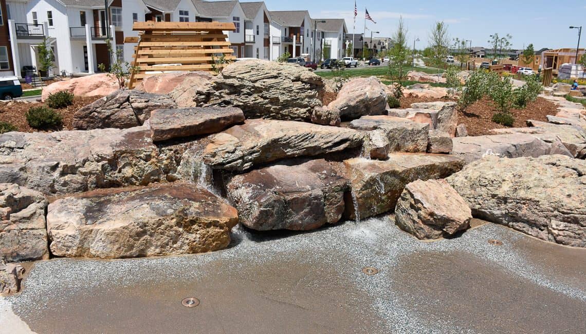 Natural boulder waterfall at stream bed in Colorado neighborhood constructed by Colorado Hardscapes.