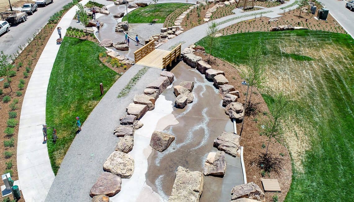 Drone view of strem bed with lithocrete and natural boulders in neighborhood in Colorado.