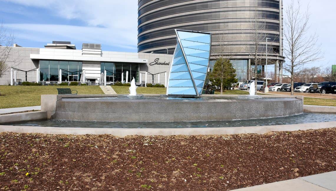 Front view of Denver Tech Center water feature with three geyser nozzles and a large prism centerpiece in front of Shanahan's Steakhouse.